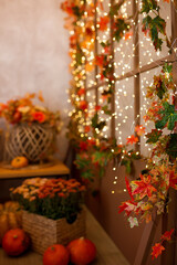 Orange pumpkin with a lovely autumn flower composition on the background of yellow and orange fallen leaves