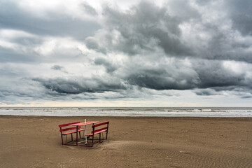 Lonely bench on the shore of a stormy sea
