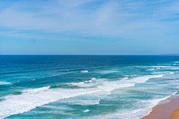 Aerial view of tropical sandy beach and ocean with turquoise water with waves. Sunny day on Atlantic ocean beach