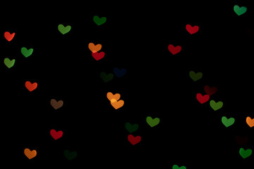Bokeh red, green and orange lights isolated on black background. Heart-shaped, love concept, Valentine's Day