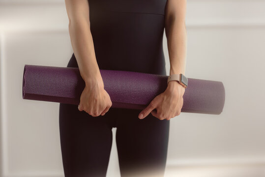 Closeup photo of fit slim woman holding exercise mat and preparing for yoga class