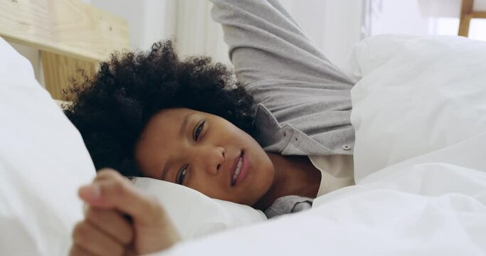 Relax, bed and sleeping with a black woman in her bedroom waking up in the morning after rest and sleep at home. Young female relaxing and happy to wake with a stretch on the weekend in her house
