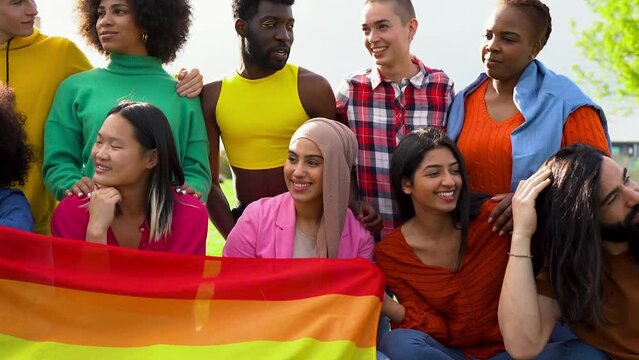 Group of happy diverse people having fun outdoor with LGBT rianbow flag