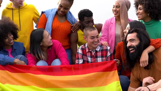 Group of happy diverse people having fun outdoor with LGBT rianbow flag