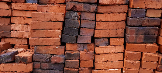Landscape photo of pile of red brick in the house construction. 