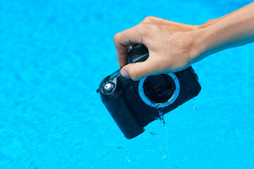 Washing dirty dslr camera in water. Crazy photographer poorly cleans the camera sensor with water....