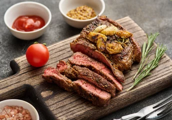  Medium rare Ribeye steak or beef steak on the wooden tray with herbs © FoodAndPhoto