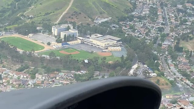 Cockpit of helicopter flying over city