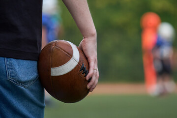 Man hold ball for american football in his hand.