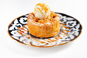 Round apple pie or tart topped with ice cream ball and sweet sauce