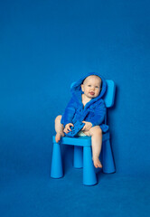 Happy child sitting on a chair holding controller