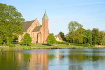 Fototapeta na wymiar Maribo Cathedral seen across the lake Søndersø