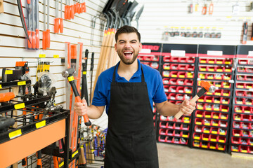 Young man looking excited while looking for a hammer at the hardware store