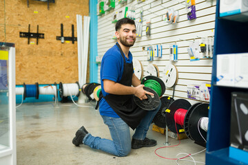 Excited hardware store worker selling electricity cable