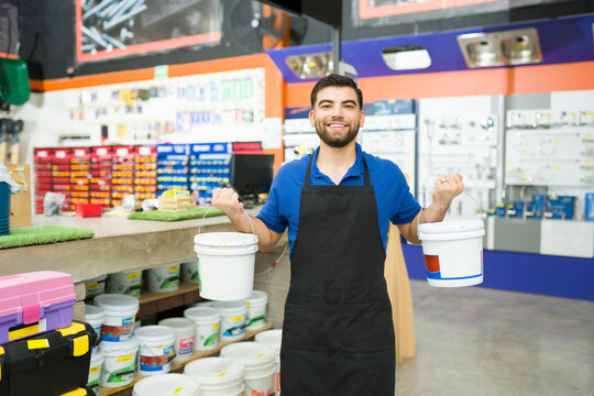 Young man and hardware store worker selling paint or waterproof buckets
