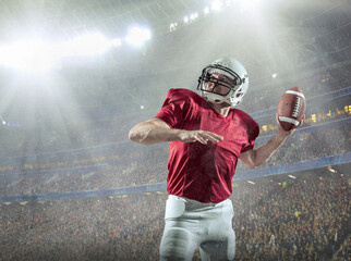American football sportsman player with ball in action on stadium under lights of background....