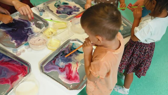 a kid creating a painting on water, creative art for kids at nursery. High quality 4k footage
