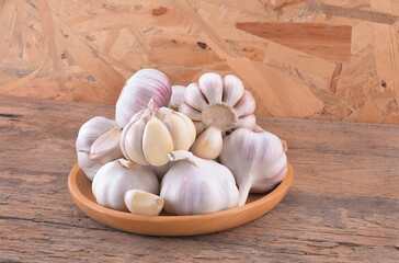 large head of garlic in a basket on wooden background