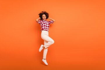 Fototapeta na wymiar Full length body size view of attractive cheery girl jumping having fun rest isolated on bright orange color background