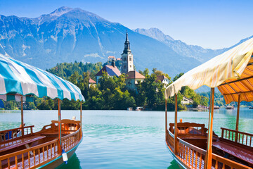 Fototapeta Typical wooden boats, in slovenian called Pletna, in the Lake Bled, the most famous lake in Slovenia with the island of the church (Europe - Slovenia) obraz