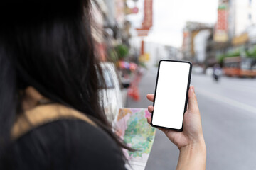 Female tourist showing modern mobile smartphone screen in Chinatown, Bangkok, Thailand
