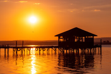 Sunset over the sea lake and old wooden pier, romantic travel destination, nature landscape