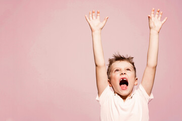 Toothless little boy with open mouth raised his hands up.