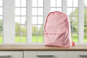 School backpack on desk and window in home interior. 