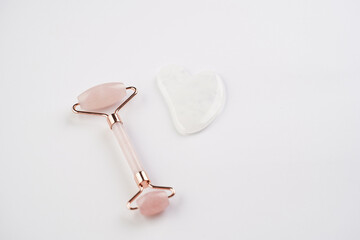 Tools for spa and face wellness cleansing - rose quartz face roller, gua sha massager, top view