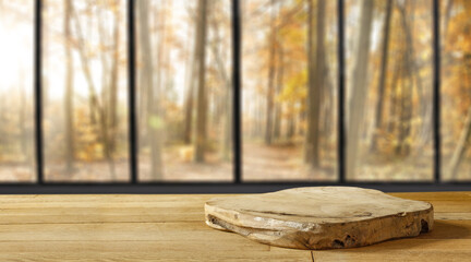 Wooden table of free space and autumn window background. 