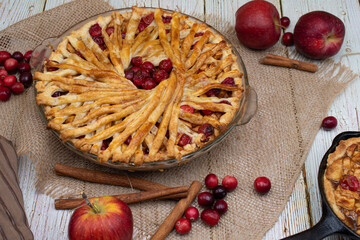 Apple Cranberry pie on burlap cloth, wooden white table