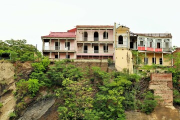Obraz premium Old abandoned houses on the edge of a steep cliff