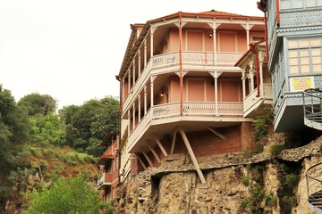 Fototapeta premium Traditional residential buildings in the old town of Tbilisi on the edge of a sheer cliff