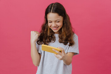 White preteen girl gesturing while playing online game on cellphone