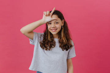 White preteen girl wearing t-shirt smiling and pointing finger upward