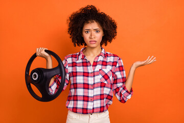 Photo of unsure uncertain young woman wear plaid shirt not knowing how control car isolated orange...