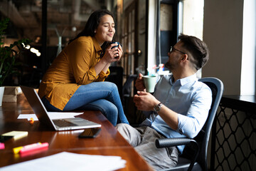 Colleagues in office. Businesswoman and businessman drinking coffee.