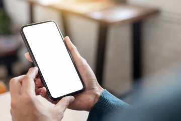 cell phone blank white screen mockup.hand holding texting using mobile on desk at office.background...