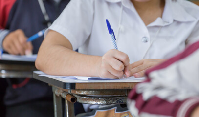 high school,university student study.hands holding pencil writing paper answer sheet.sitting lecture chair taking final exam attending in examination classroom.concept scholarship for education abroad