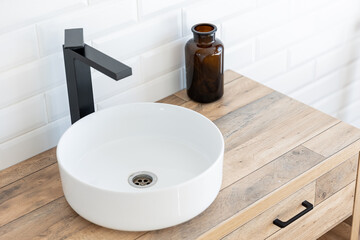 Black faucet for water and white separate high sink on wooden pedestal, top view. Loft style...
