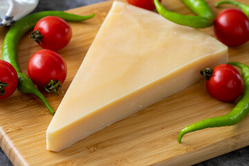 Parmesan cheese. Italian parmesan cheese on a wooden serving platter. close up