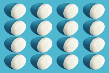 Pattern boiled eggs with shadow on blue background with sunlight.
