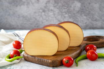Smoked cheese. Dutch smoked cheese on stone background. close up