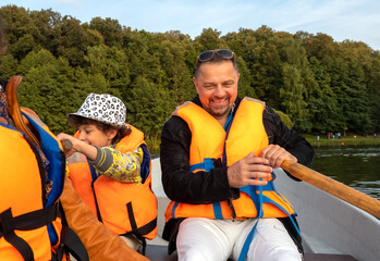 Friendly caucasian family floating on kayak with paddles. Concept of family rest, leisure and...