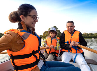 Friendly caucasian family floating on kayak with paddles. Concept of family rest, leisure and weekend at nature. father and daughter wearing life vests. autumn sunny day.Selective focus