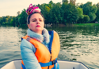 Middle aged woman with fancy hair wearing yellow life jacket over white background with snobbish expression looking with skeptical expression, chin up