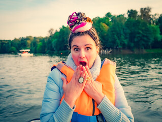 Middle aged woman with fancy hair wearing nautical lifejacket scared and amazed with open mouth for...