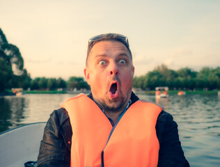 Middle aged handsome man wearing nautical lifejacket afraid and shocked with surprise expression,...