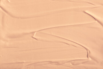 Foundation smeared as a swatch as a close-up background. Makeup cosmetics. Tone cream. Concealer texture.