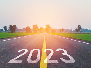 Concept of NEW YEAR and New Road With The word 2022 to 2023 Written on The asphalt road in beautiful country road With green rice fields on both sides Concept for the new year or vision of 2023